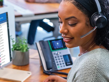 Cloud Telephony - Business Woman At Desk Wearing Headset